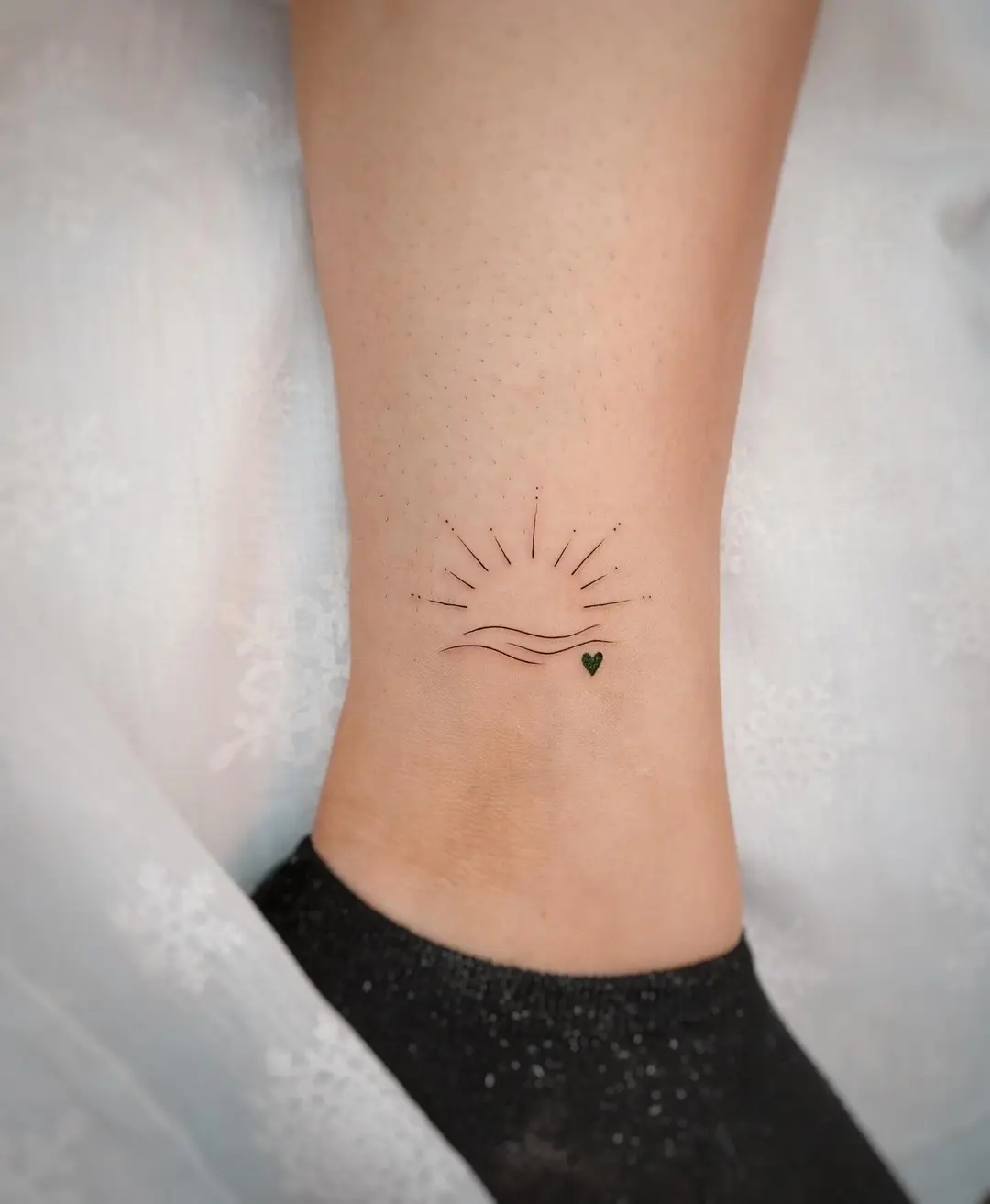 Minimalist sunrise tattoo with delicate lines