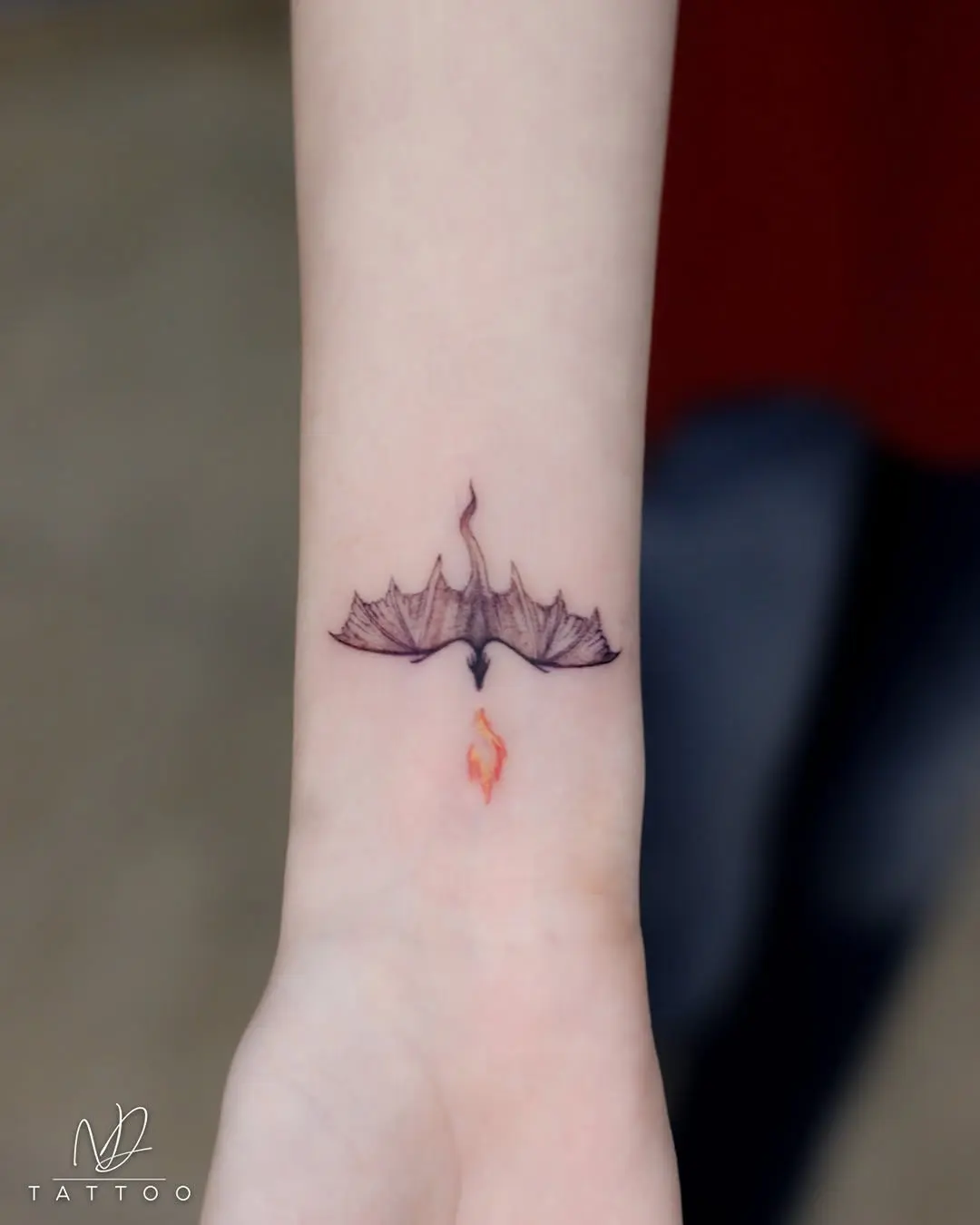 Elegant small bird tattoo with flame detail