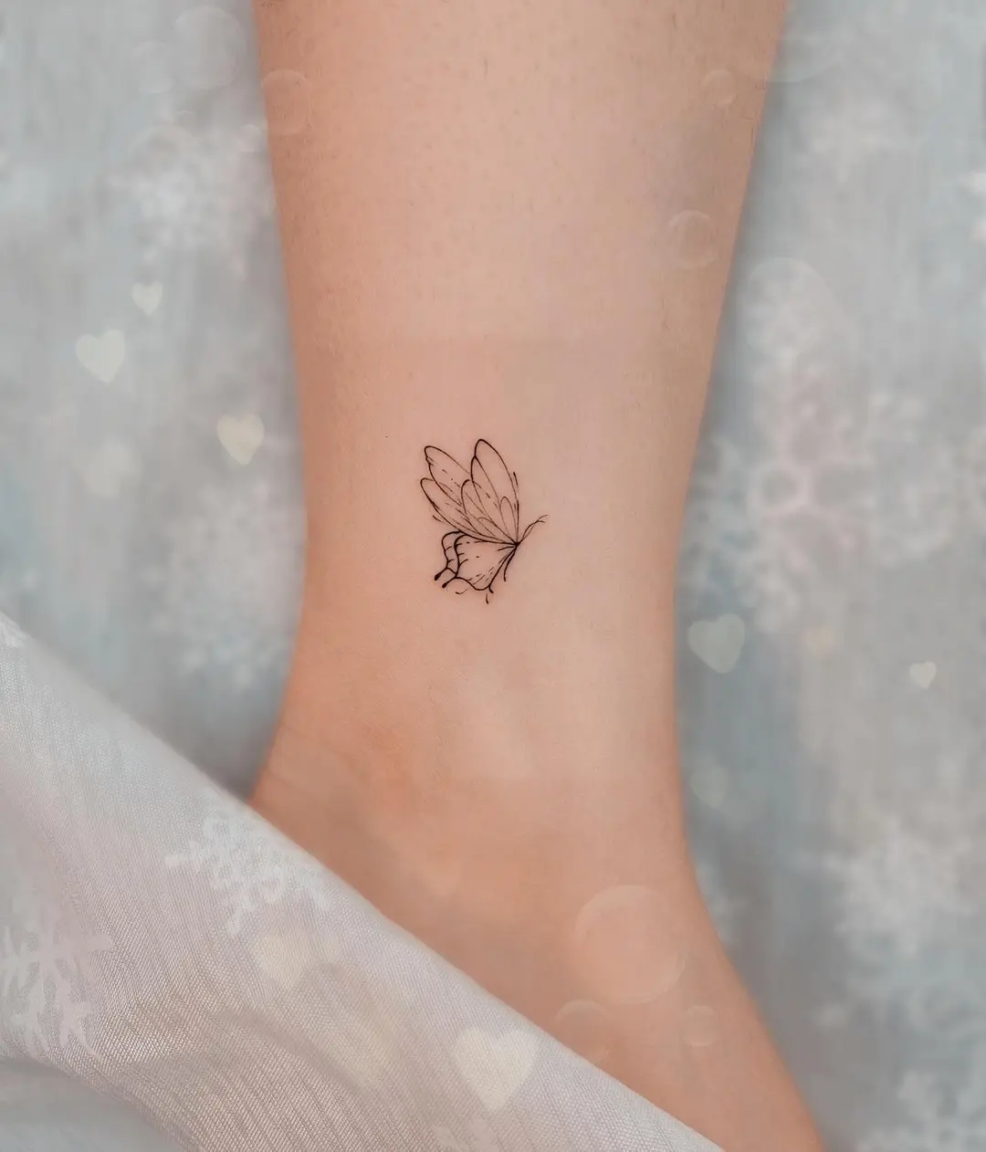 Delicate butterfly tattoo on the ankle
