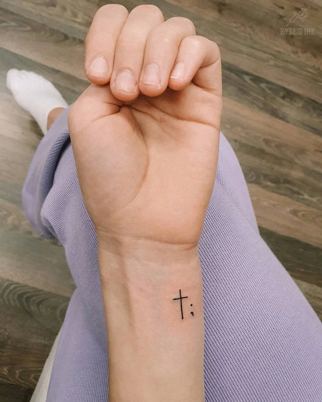 Minimalist cross tattoo on wrist