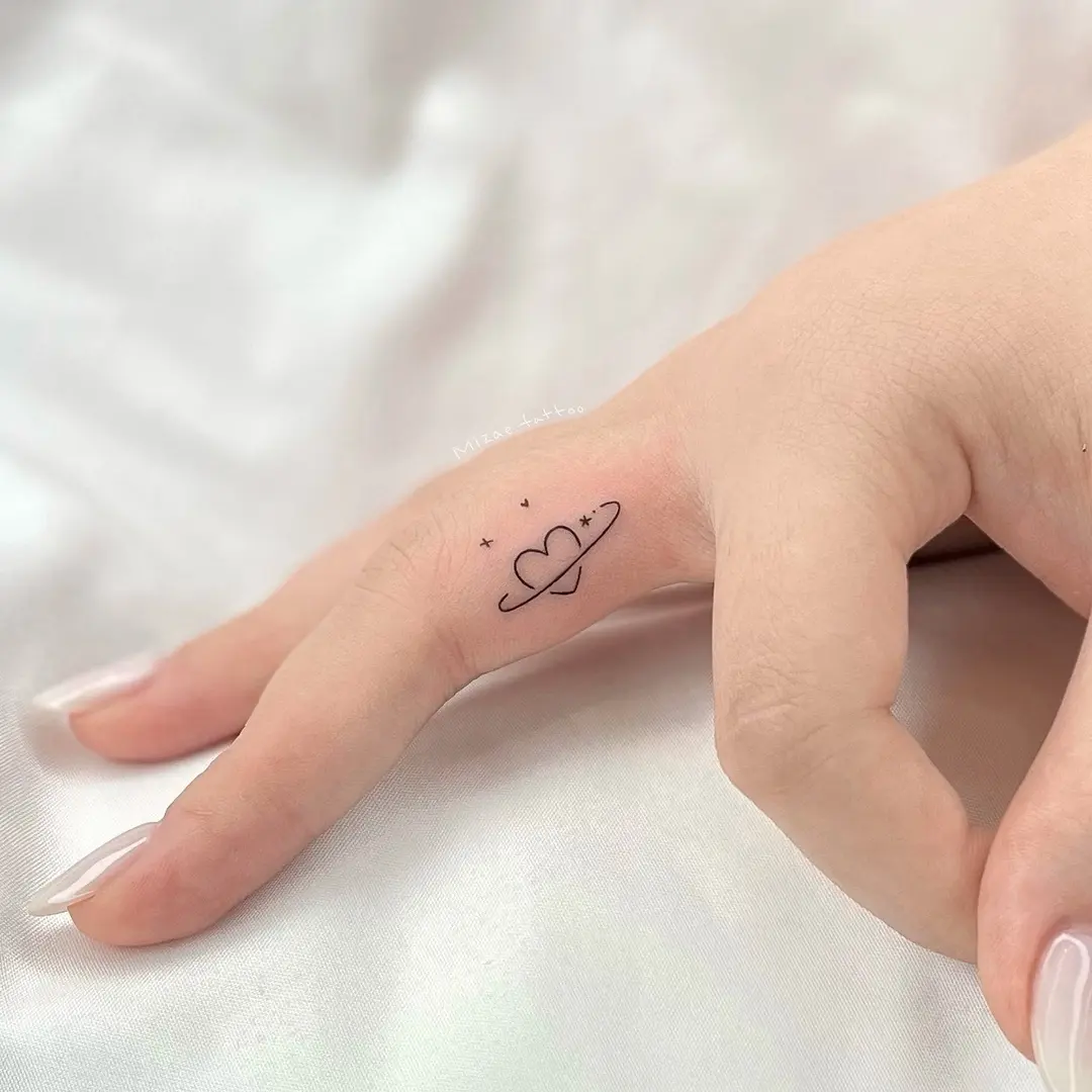 Charming heart and planet tattoo on hand