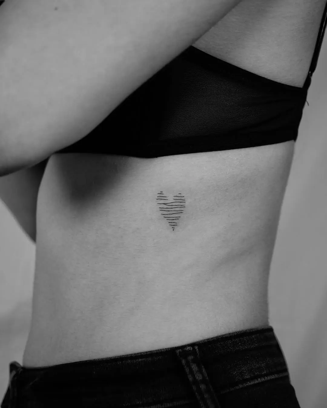 Minimalist heart tattoo with striped design