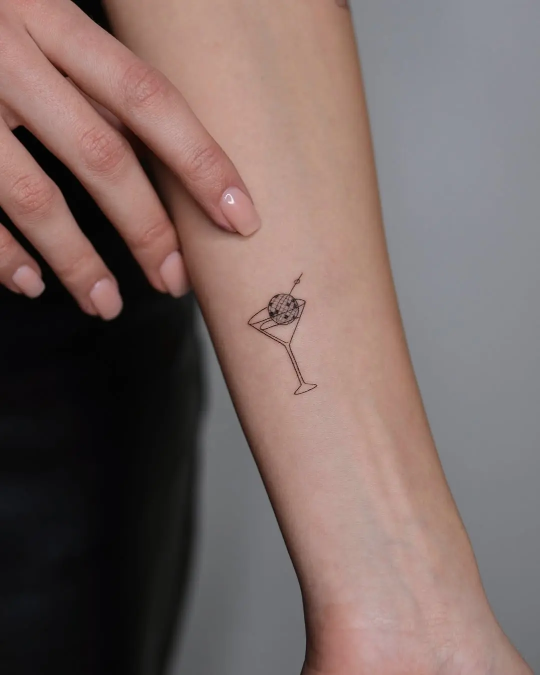 Playful small martini glass tattoo design