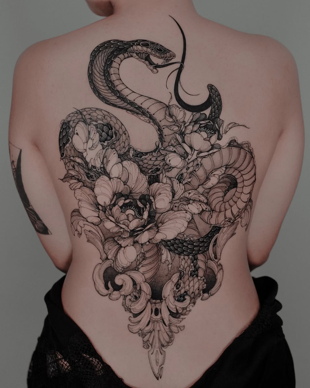 Elegant snake and floral back tattoo design