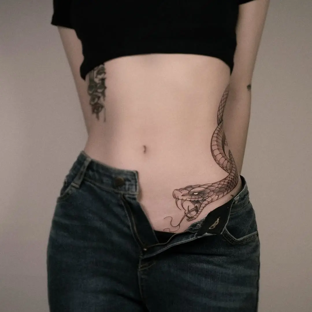 Intricate snake and floral waist tattoo design