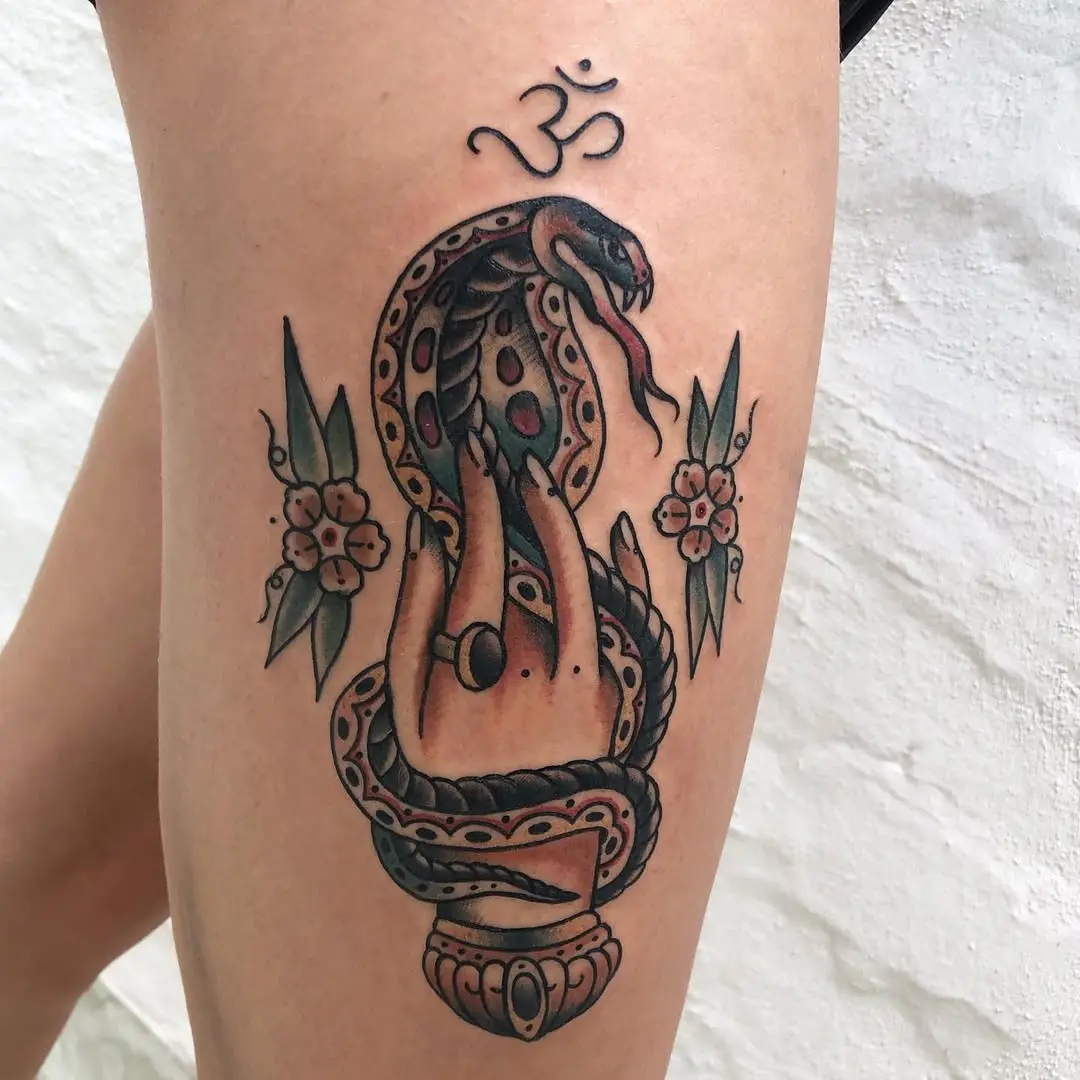Intricate snake and hand tattoo with floral accents