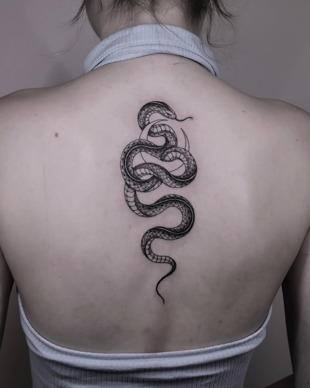 Elegant snake tattoo on the upper back