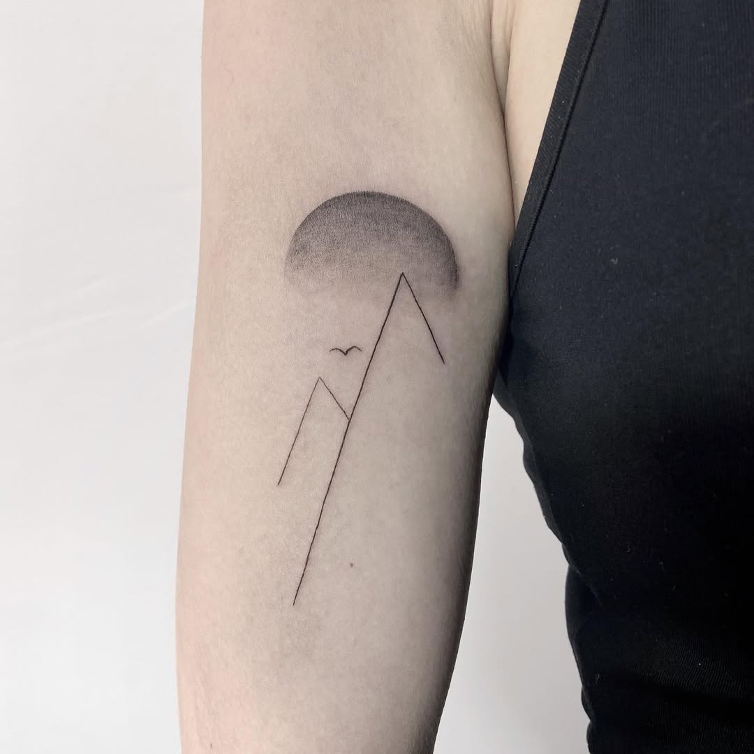 Minimalist sun and mountain tattoo inspiration