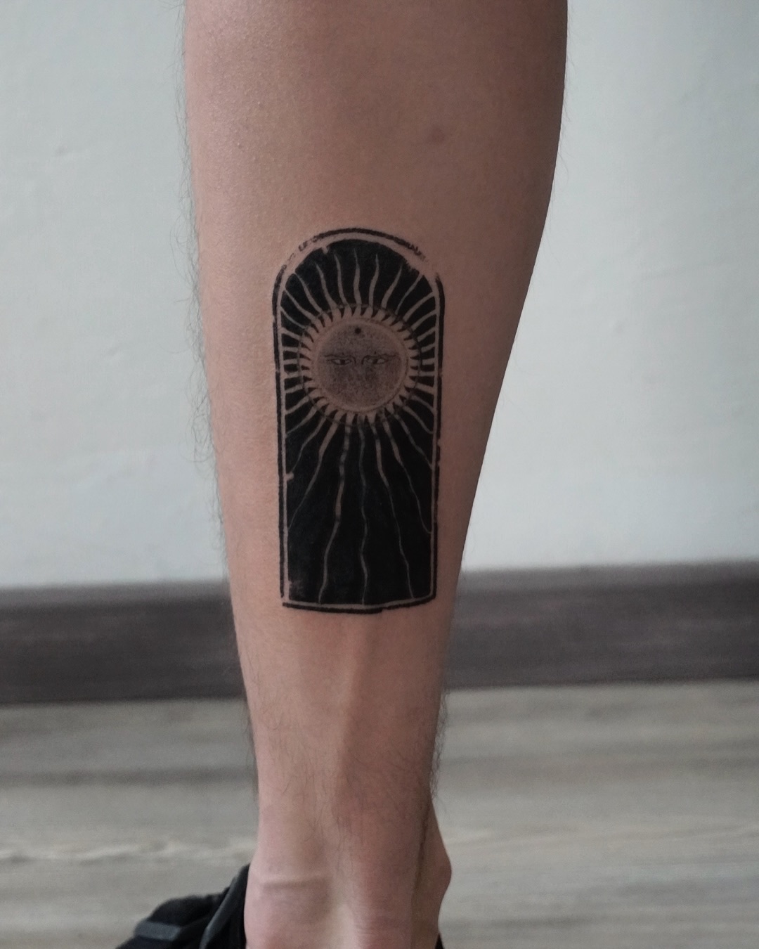 Bold blackwork sun tattoo on the leg