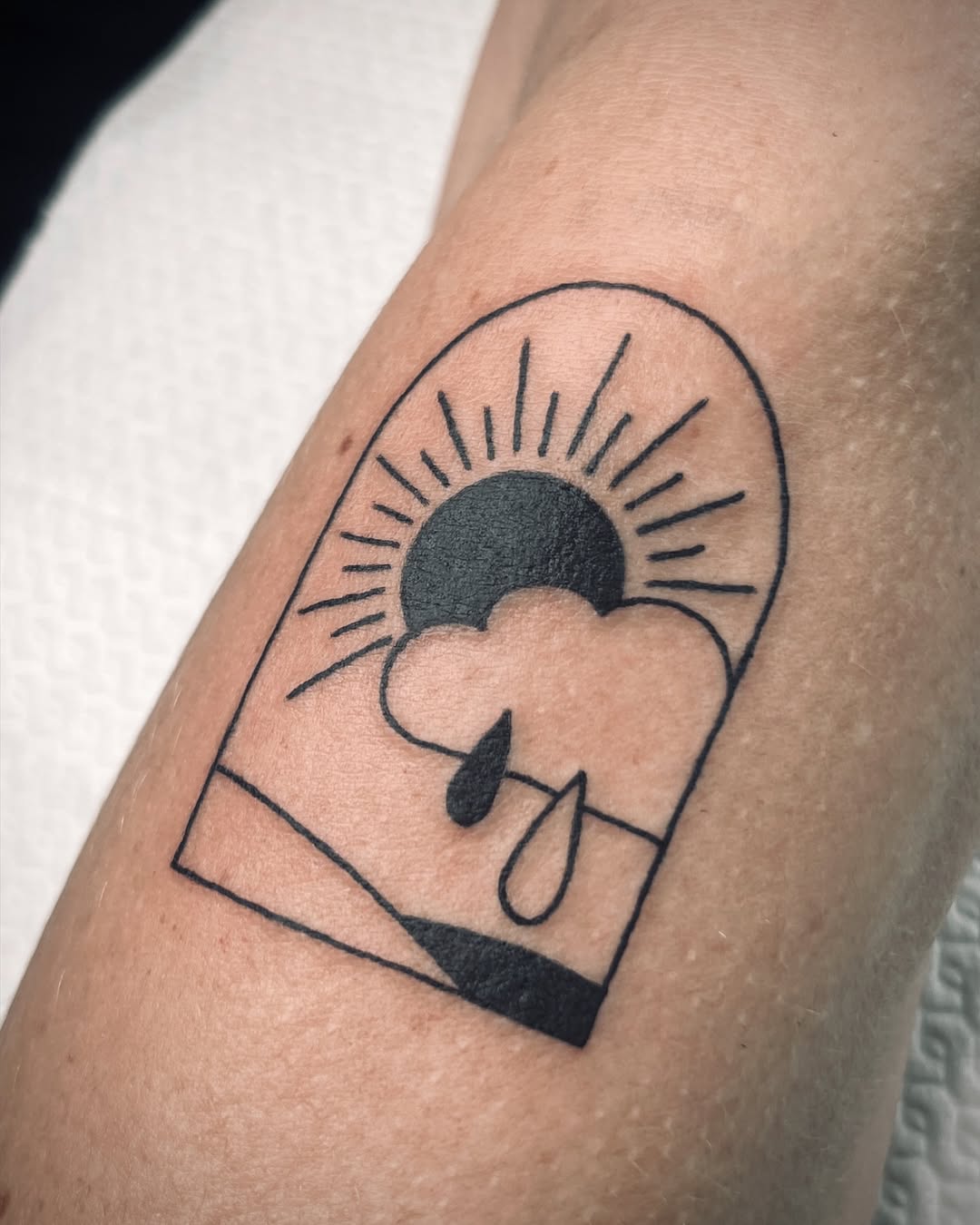 Minimalist sun and cloud tattoo design