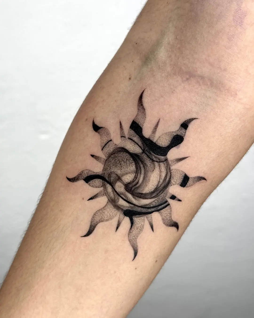 Stylish black sun tattoo design on arm