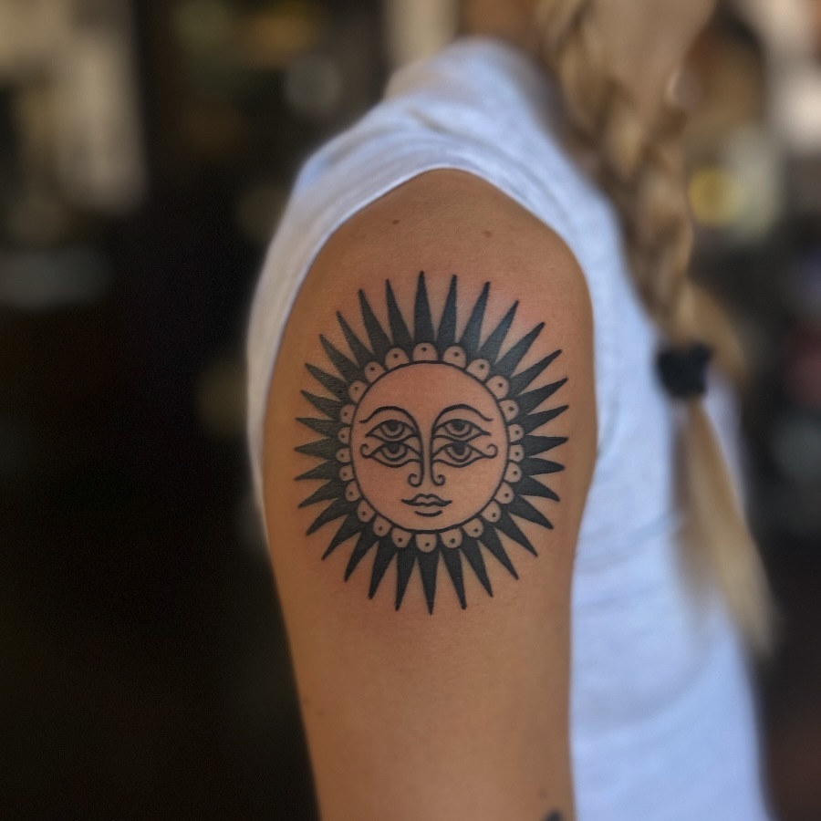 Striking sun tattoo with detailed facial features