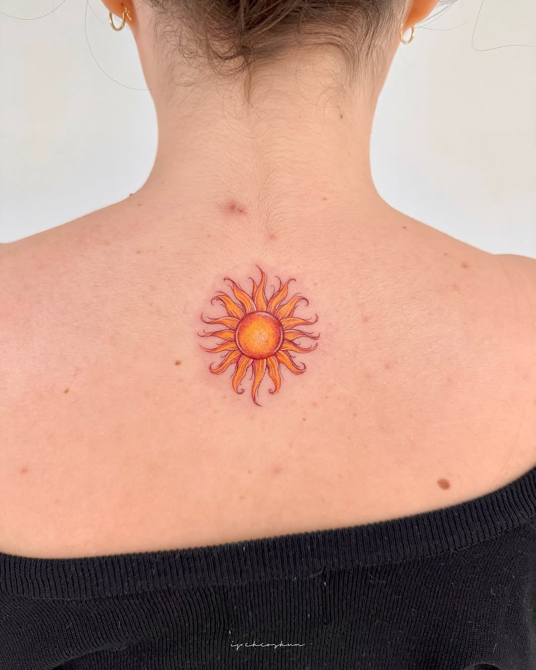 Vibrant sun tattoo radiating positivity and warmth