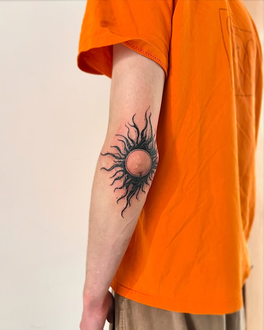 Stylish sun tattoo radiating positive energy