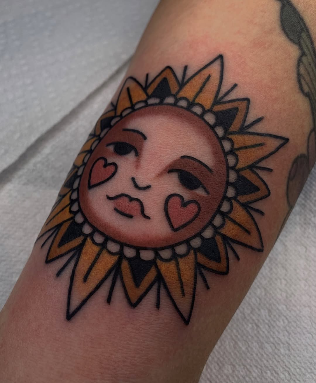 Charming sun tattoo with heart accents