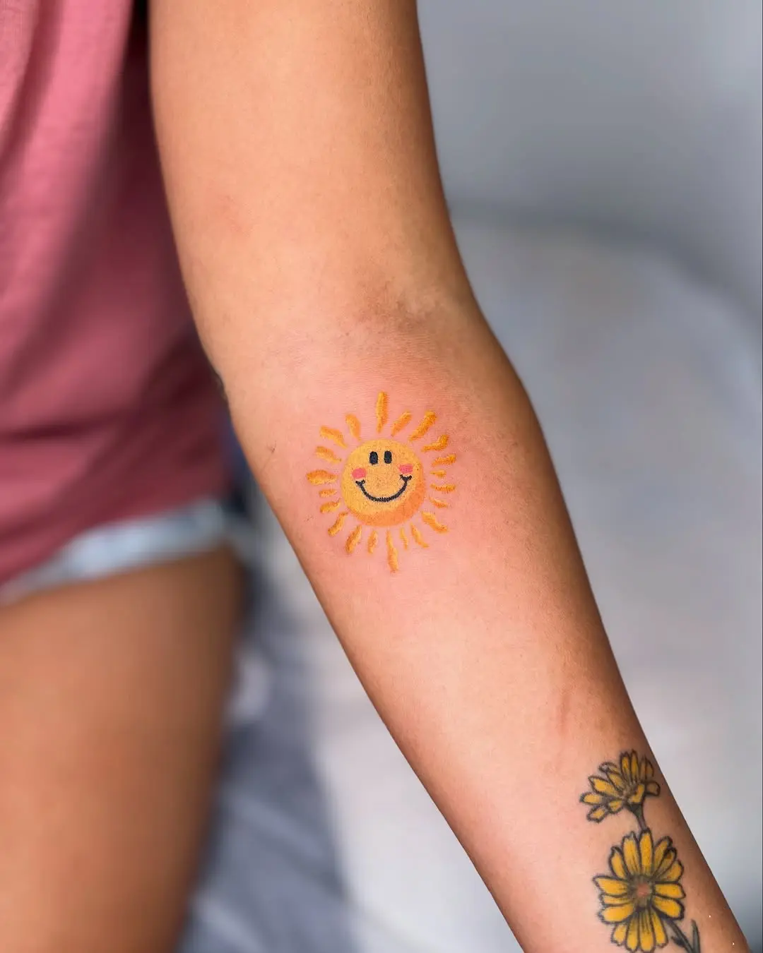 Cheerful sun tattoo radiating positivity