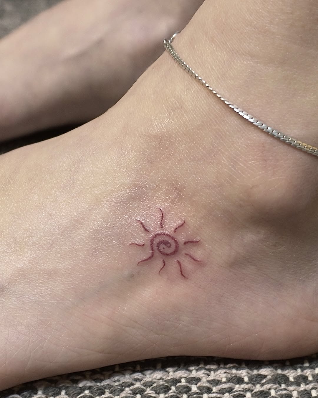 Charming minimalist sun tattoo on ankle