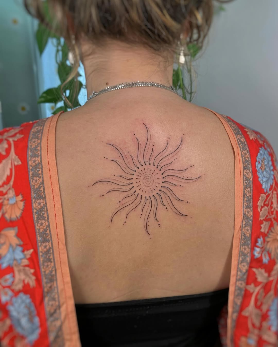 Minimalist sun tattoo radiating positive vibes