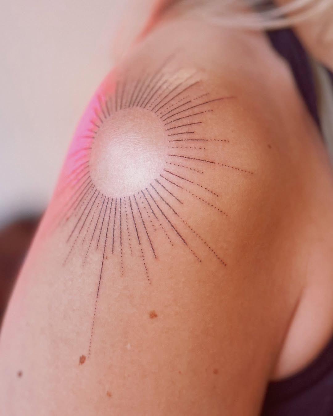 Minimalist sun tattoo radiates serene vibes