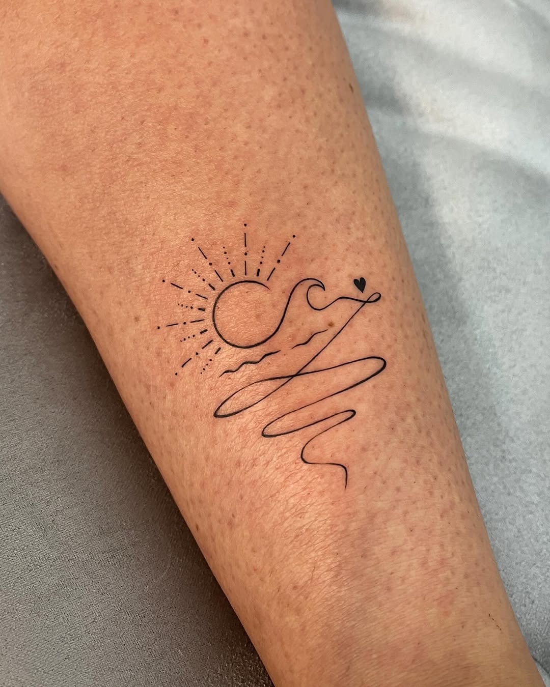 Stylish sun tattoo with flowing lines