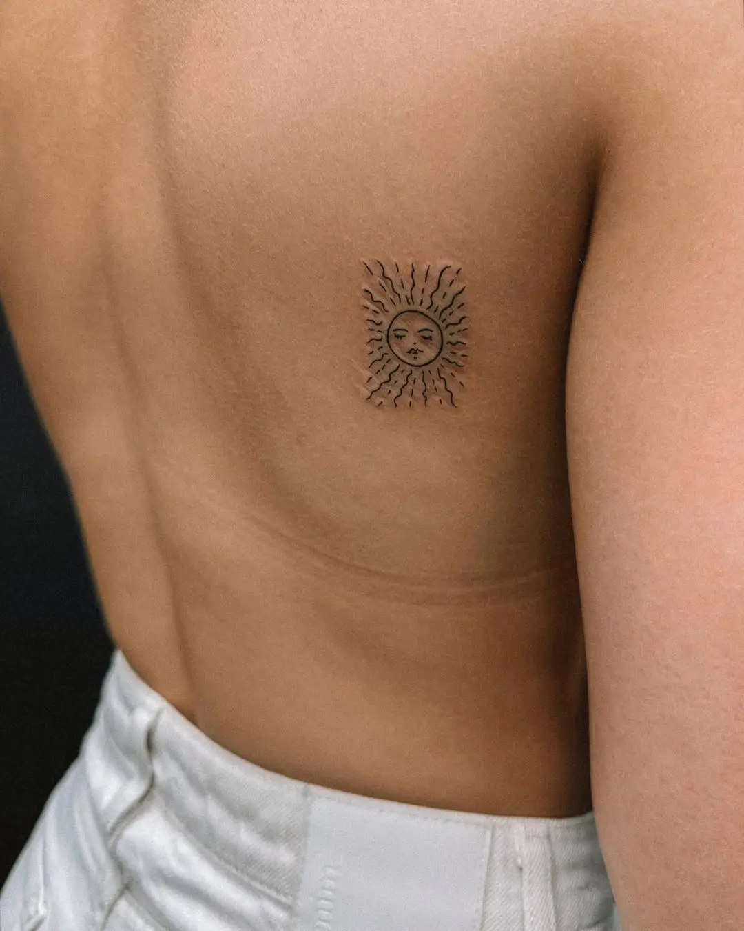 Stylish minimalist sun tattoo design on back