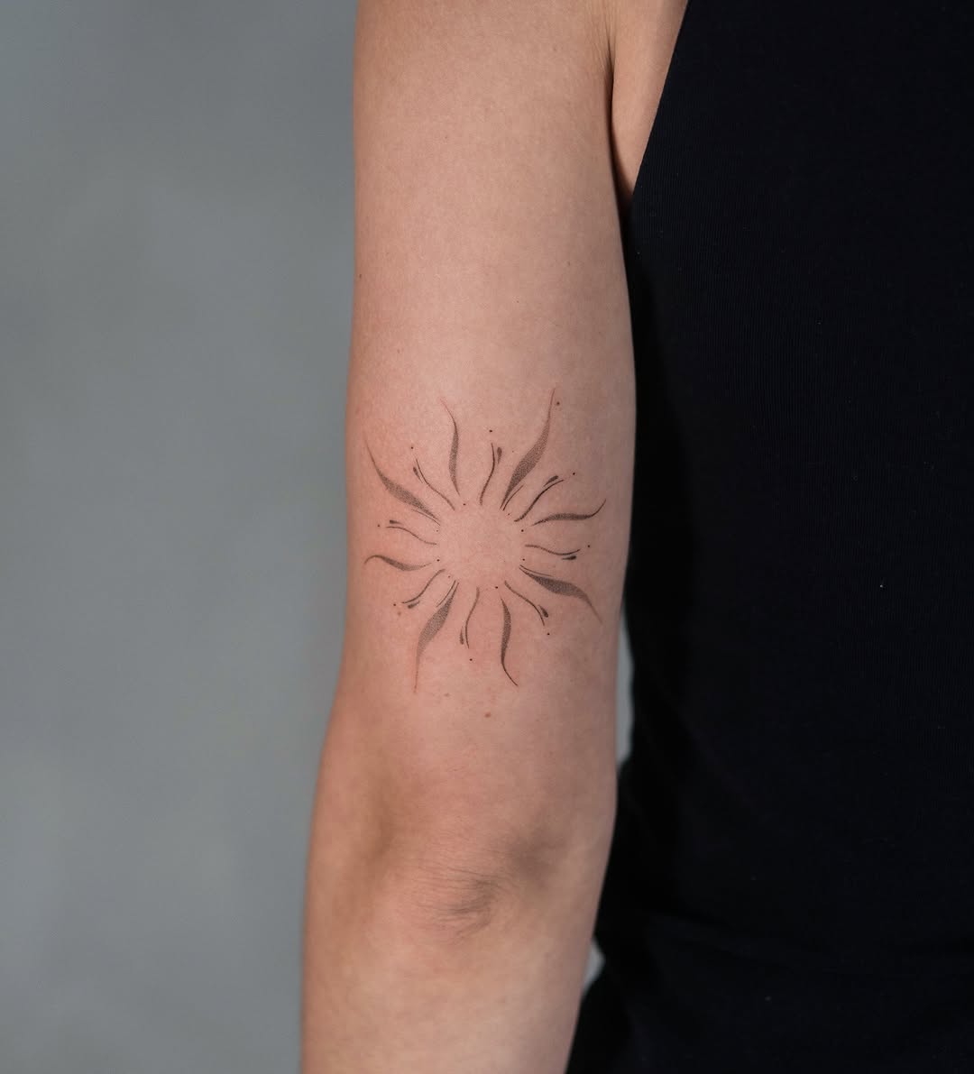 Stylish minimal sun tattoo on arm