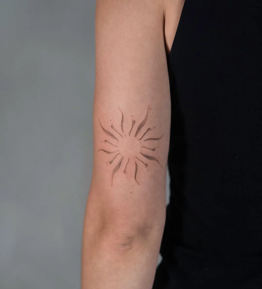 Stylish minimal sun tattoo on arm