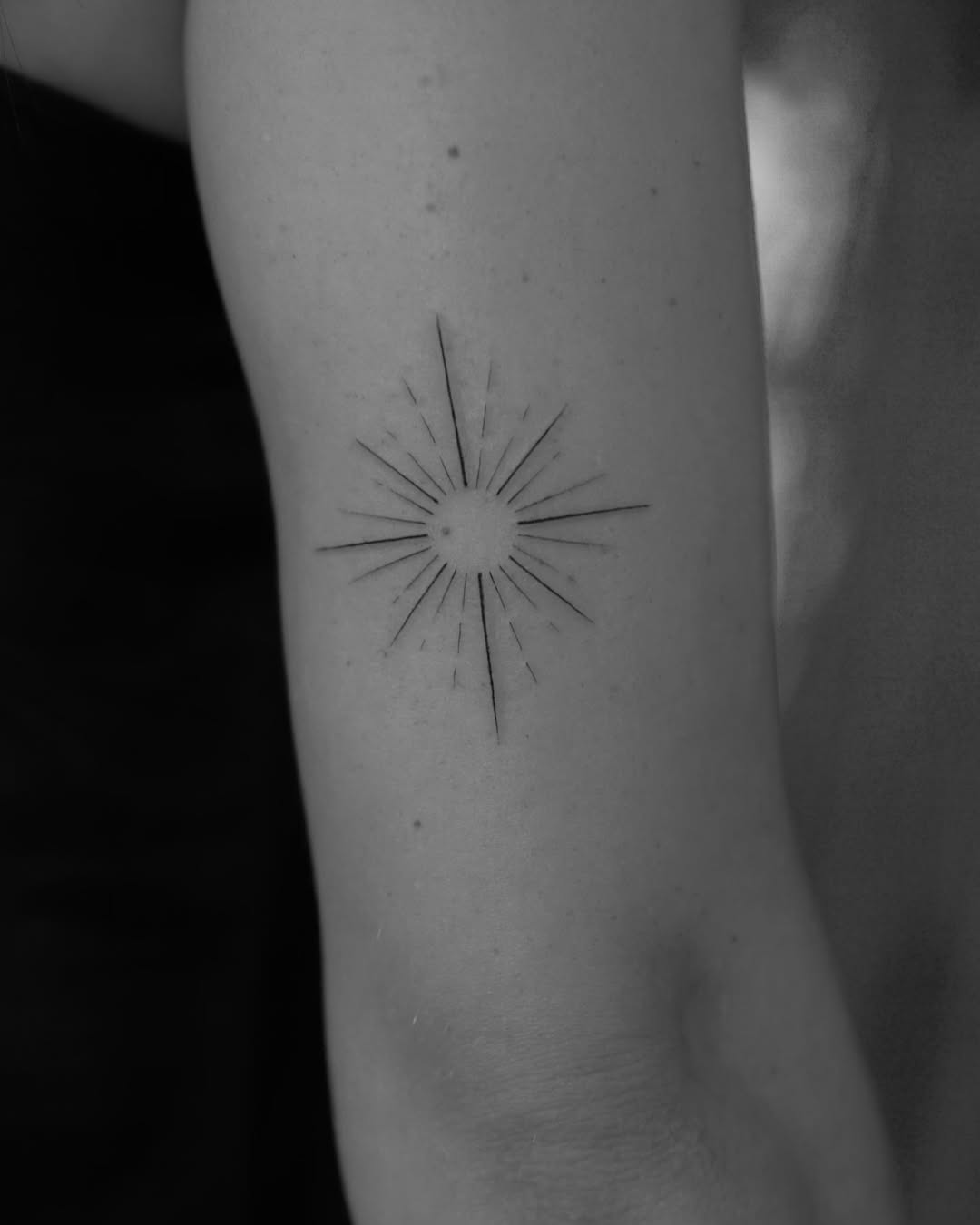 Elegant minimalistic sunburst tattoo design