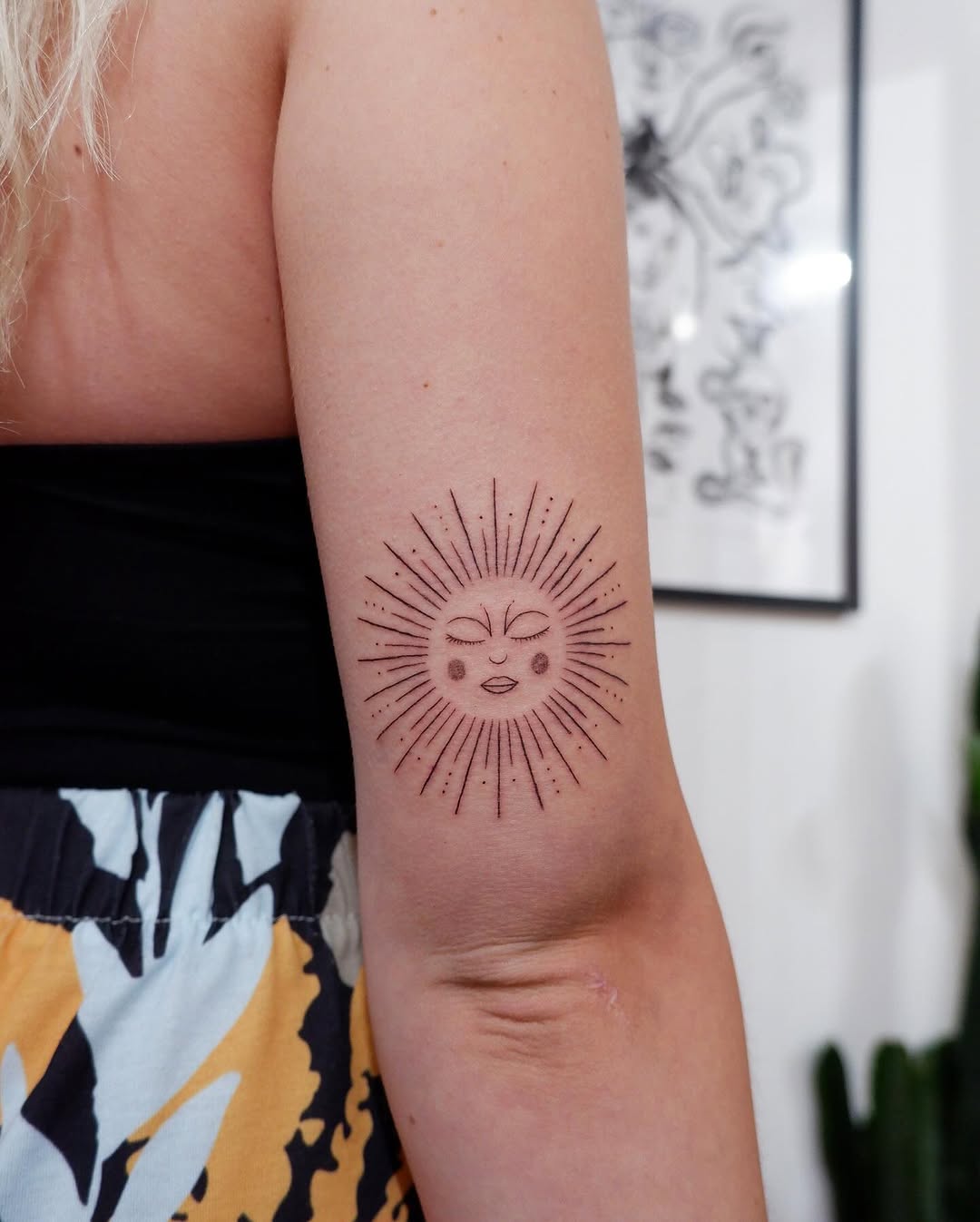 Stylish sun tattoo with charming facial features