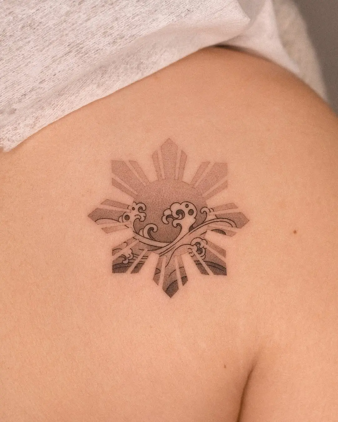 Elegant sun and wave tattoo design inspiration