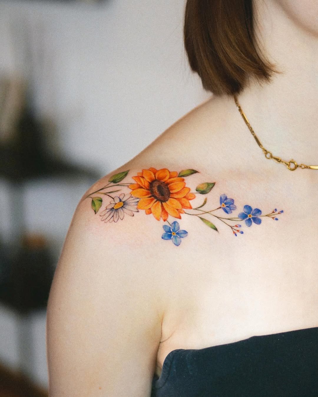 Vibrant sunflower tattoo accented with delicate flowers