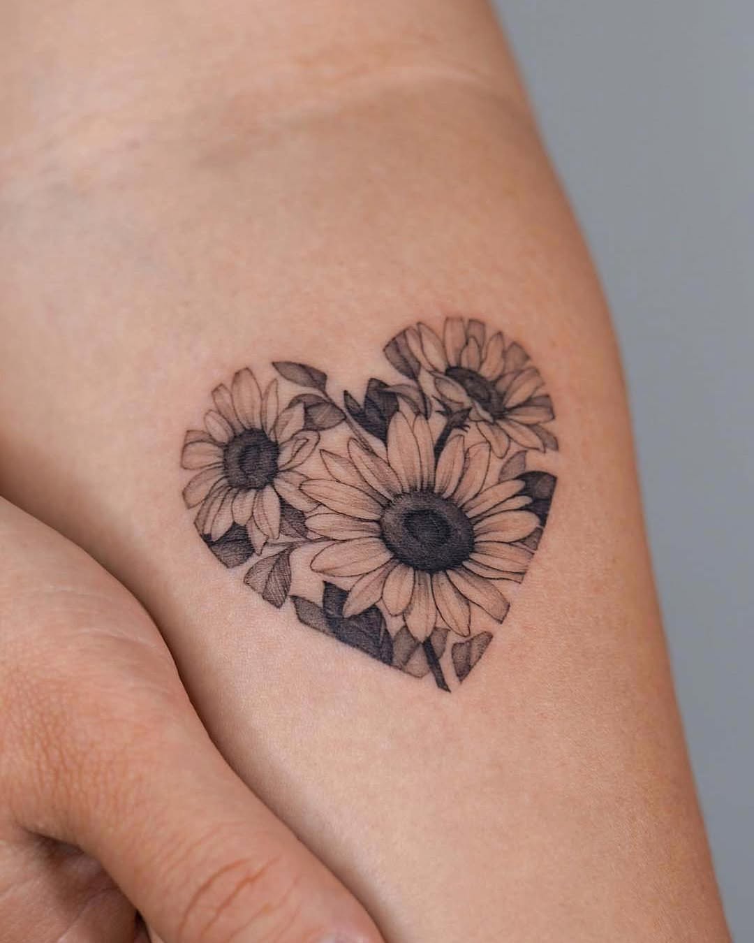 Heart-shaped sunflower tattoo with fine details