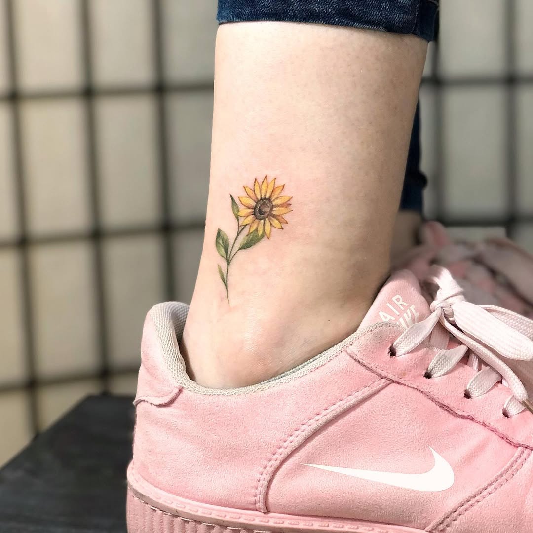 Charming sunflower tattoo above pink sneakers