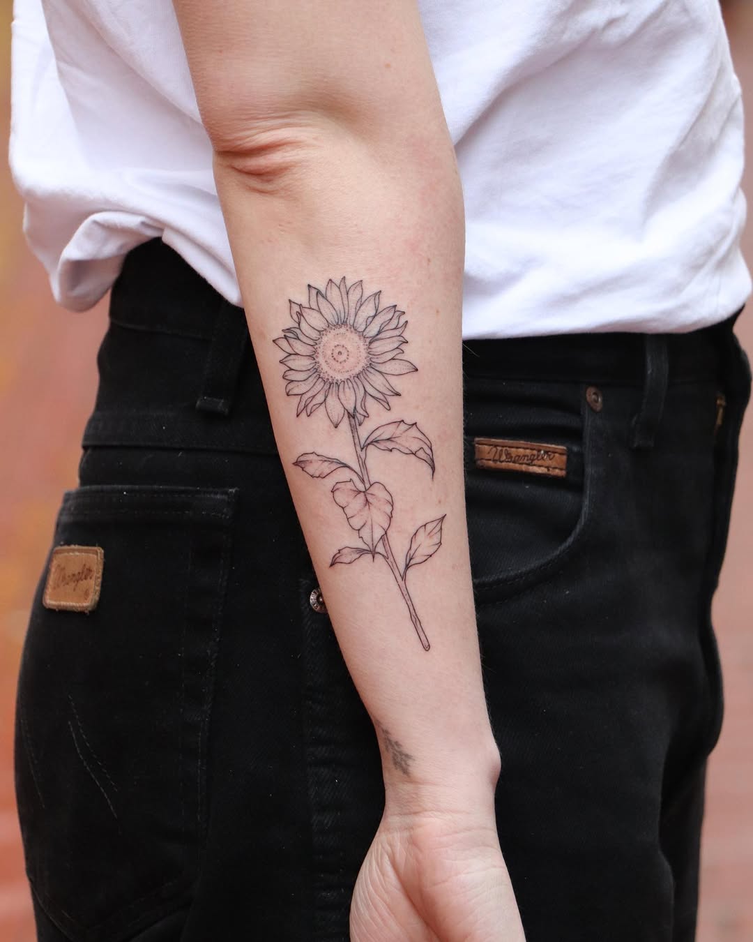 Elegant sunflower tattoo on forearm