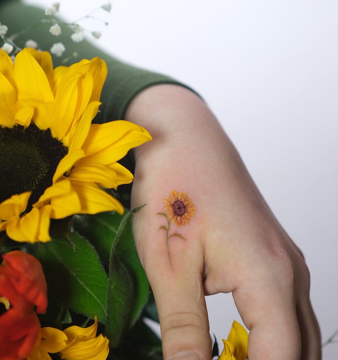 Delicate sunflower tattoo on a hand