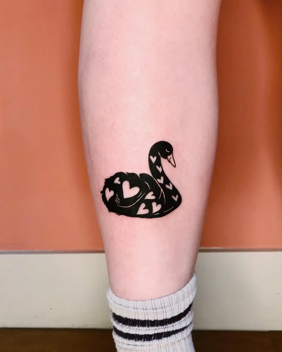 Elegant swan tattoo with heart motifs