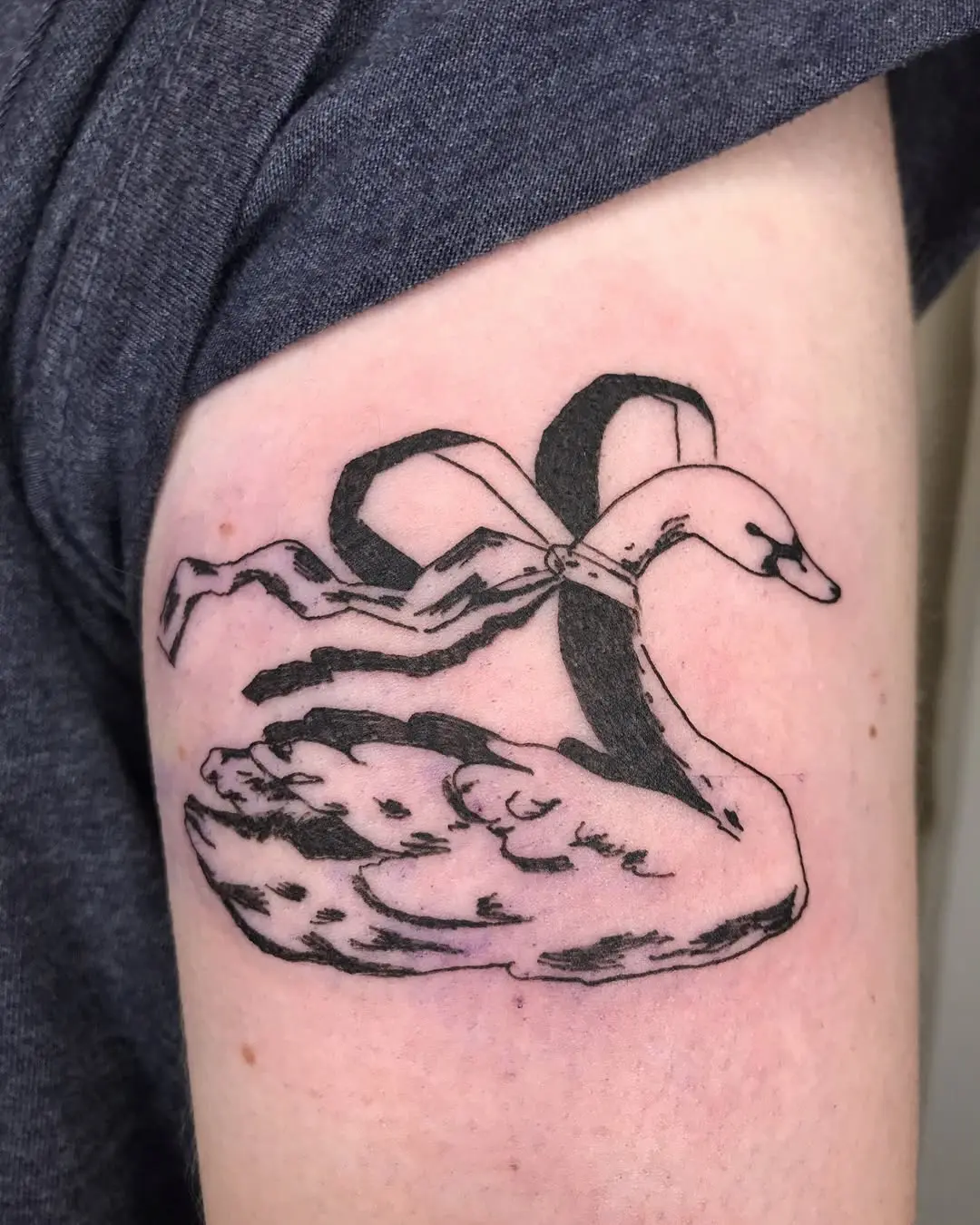 Elegant swan tattoo with a delicate ribbon