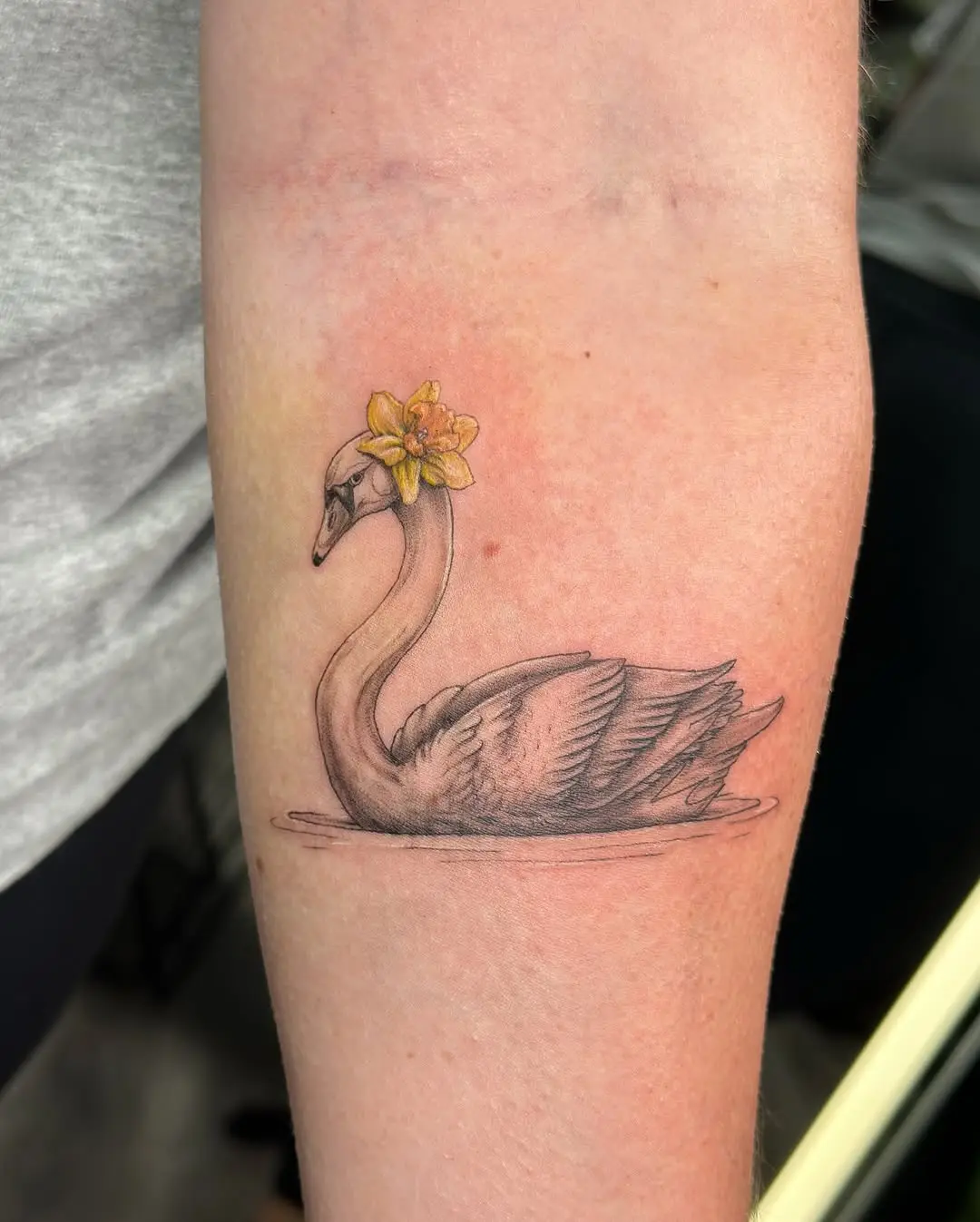 Elegant swan tattoo with floral accents