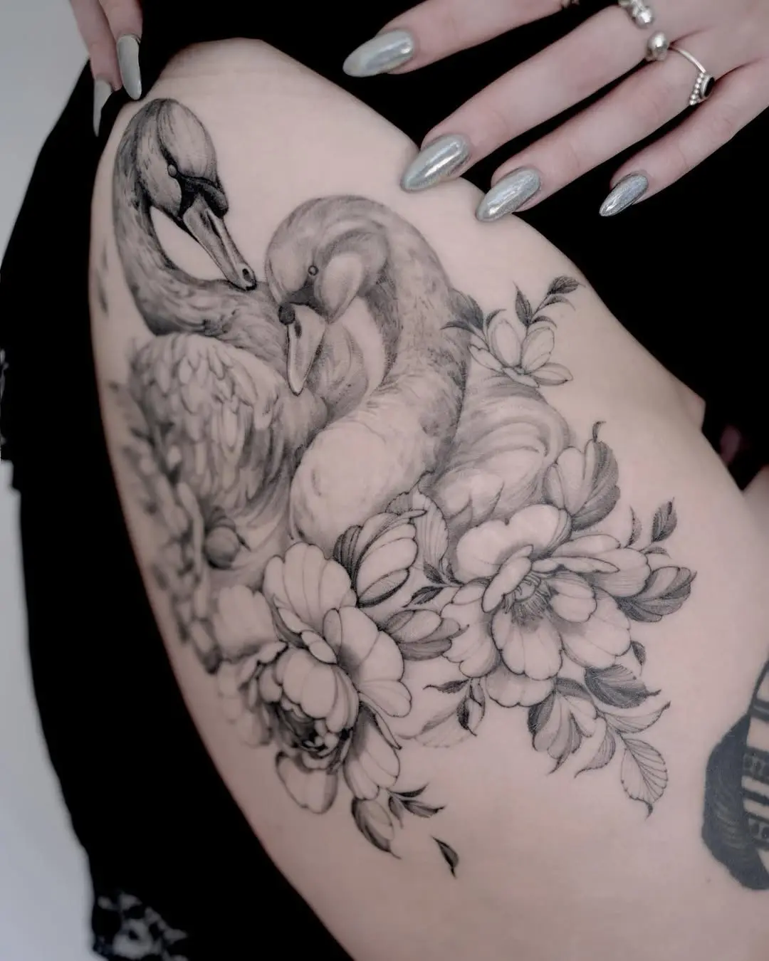 Elegant swan tattoo surrounded by floral elements