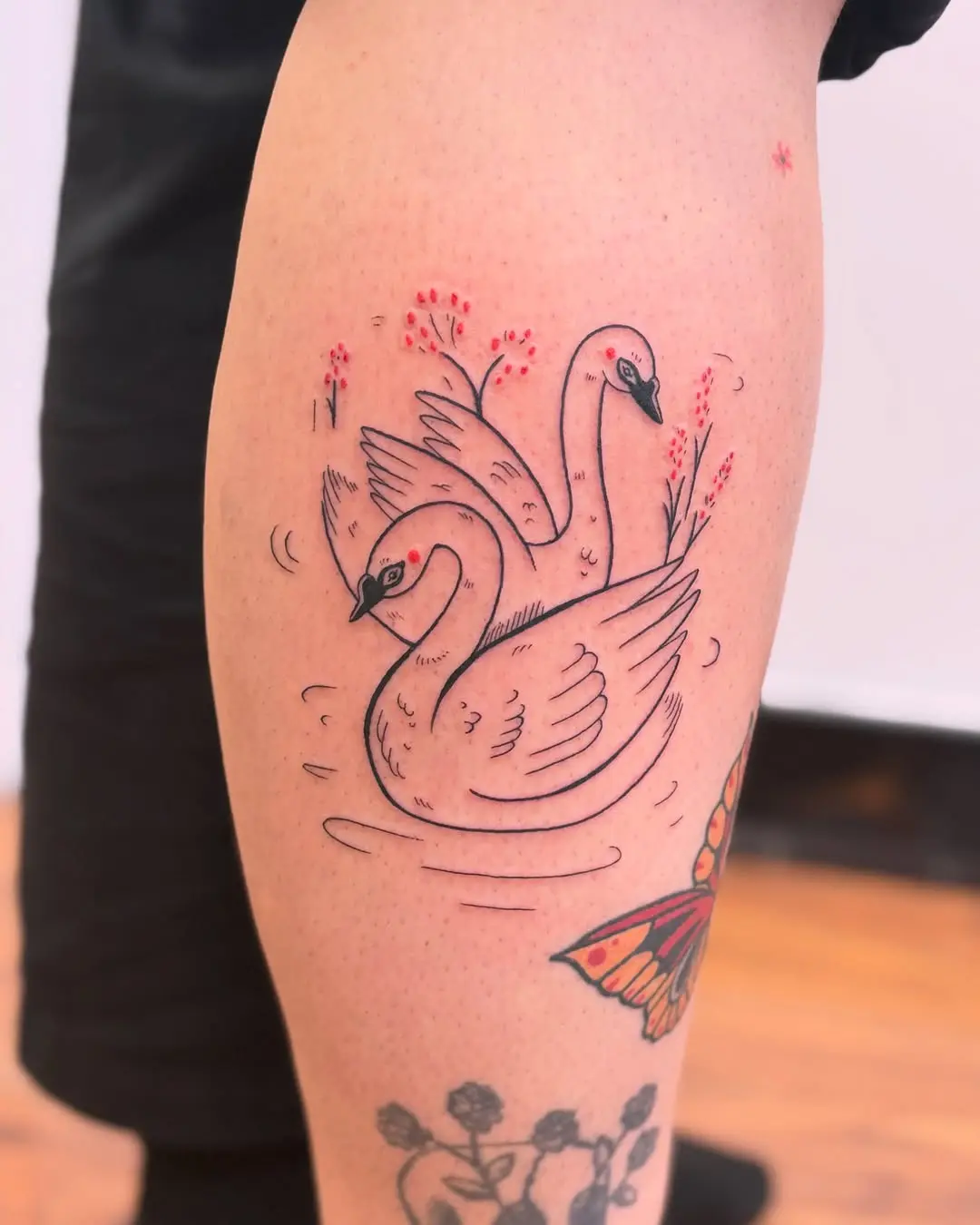 Elegant swan tattoo with floral elements