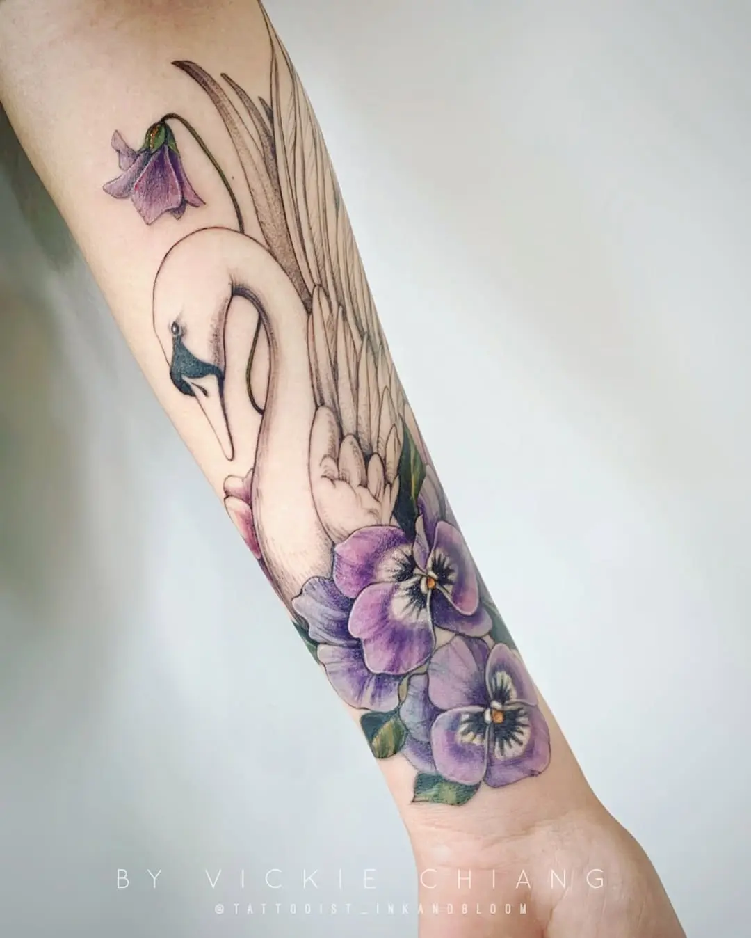 Elegant swan tattoo with floral accents