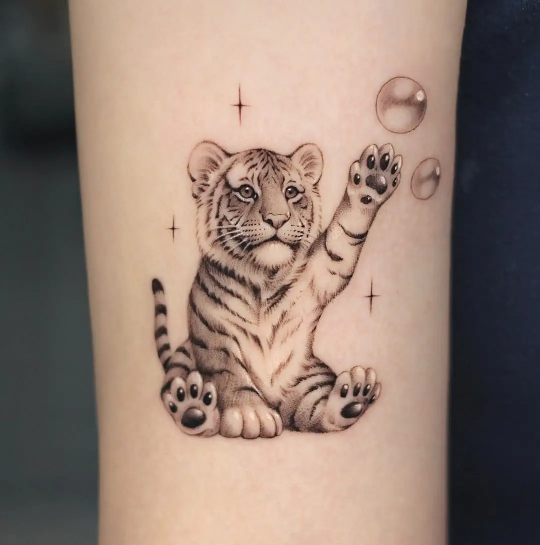 Adorable tiger cub with playful bubbles tattoo