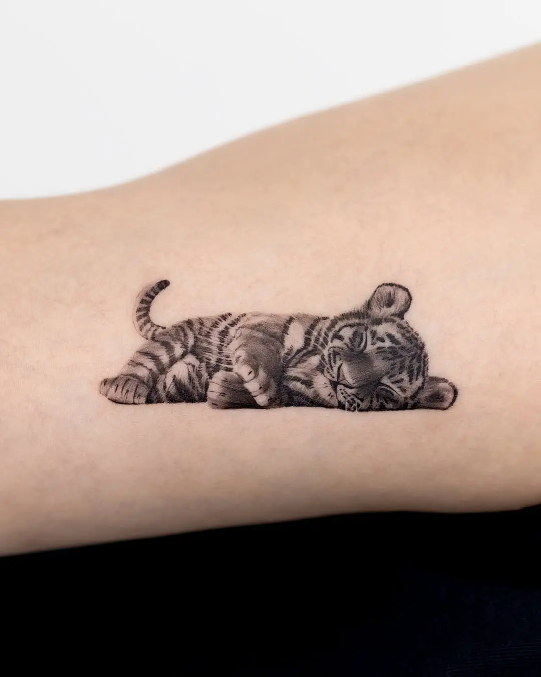 Adorable sleeping tiger cub tattoo design