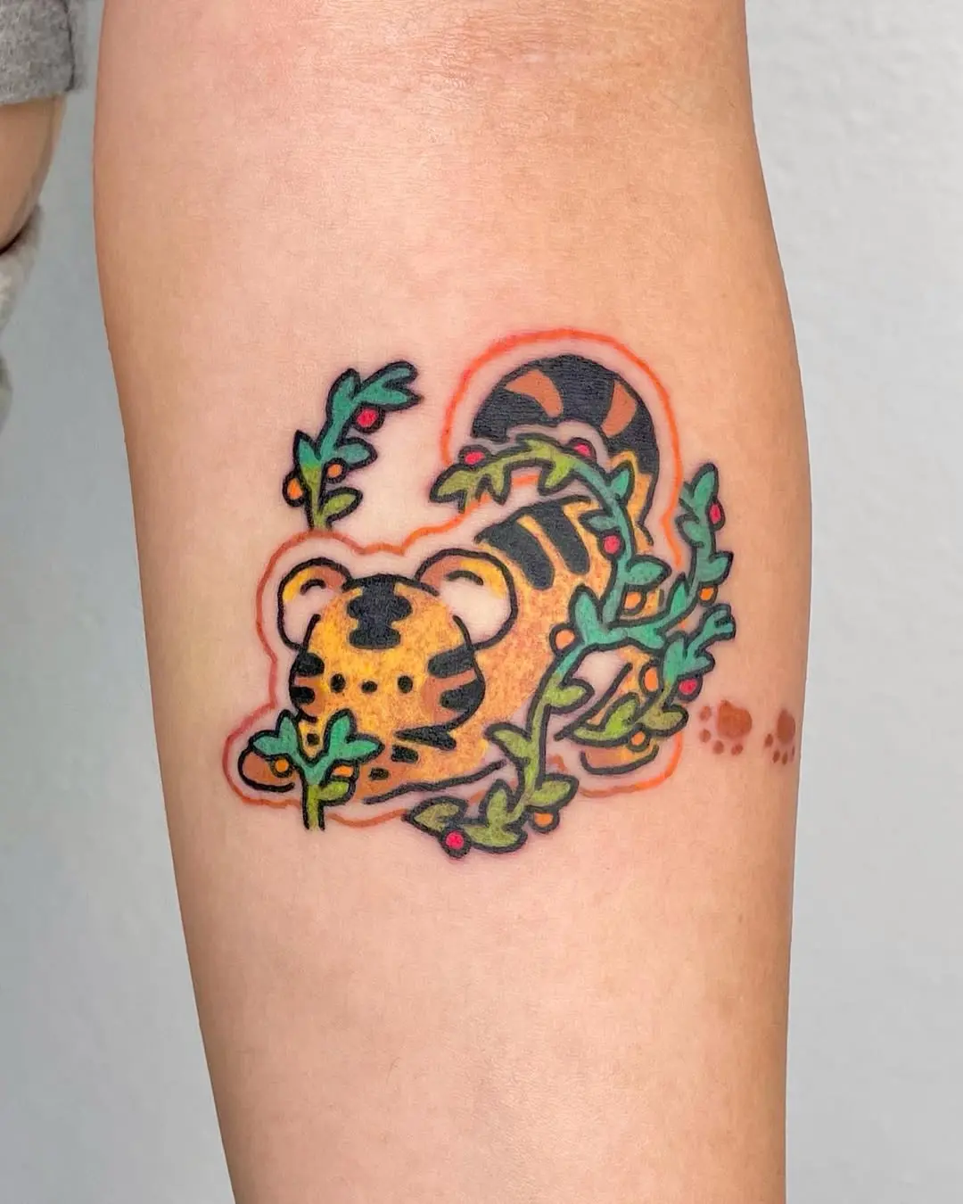 Whimsical tiger tattoo surrounded by lush greenery