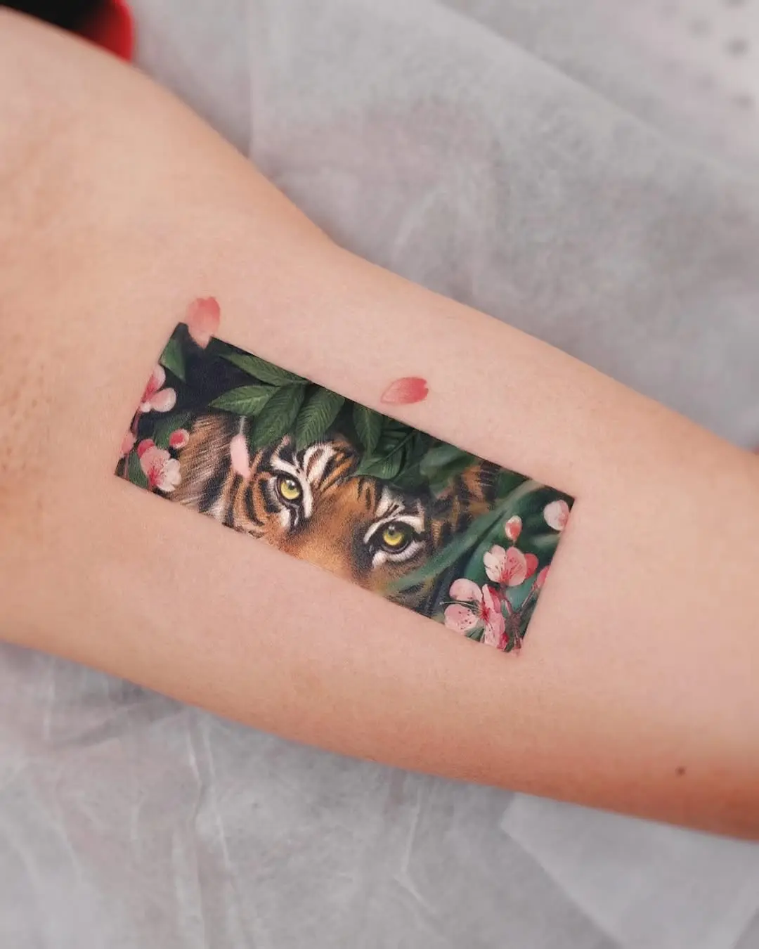 Vibrant tiger tattoo amidst floral elements