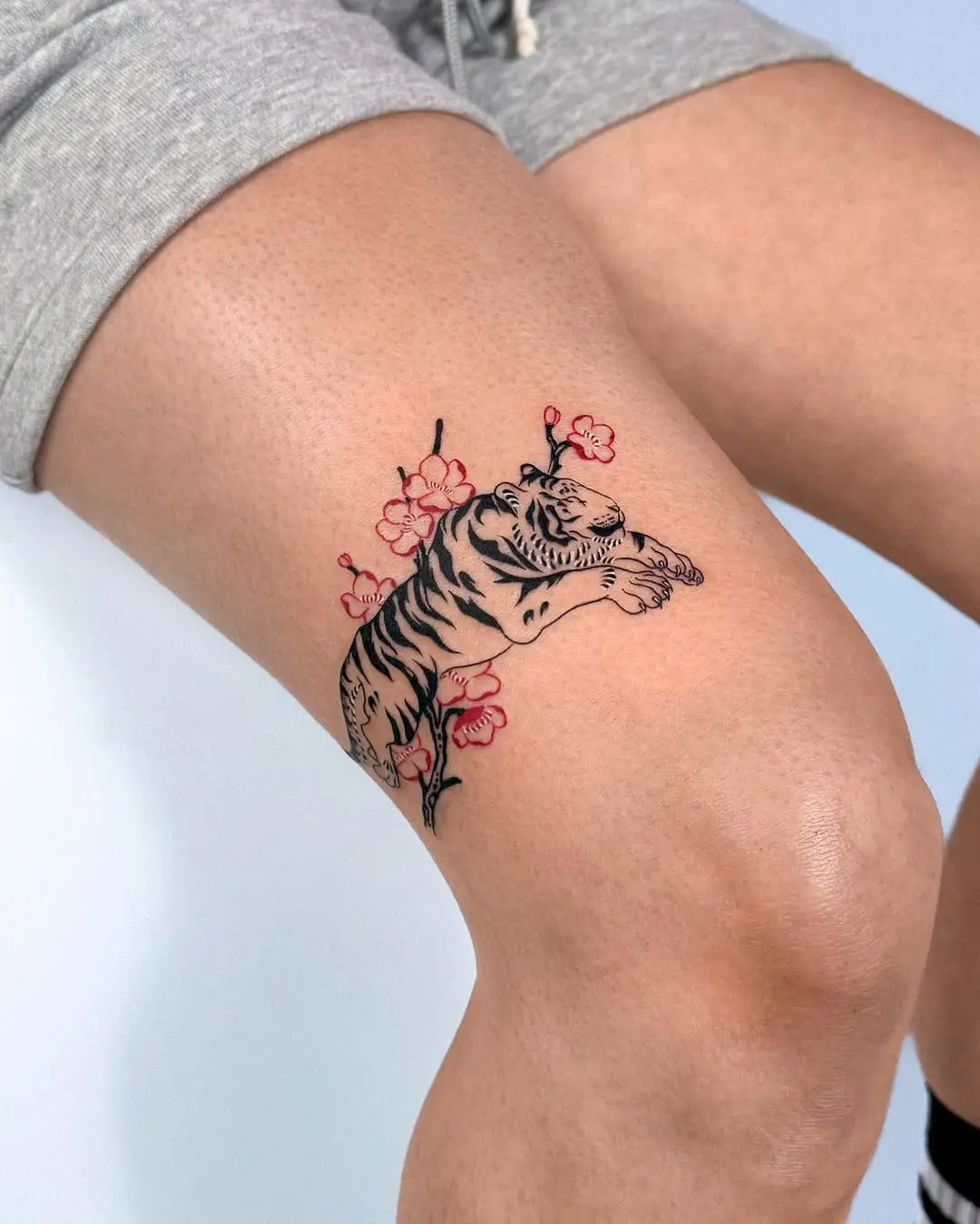 Bold tiger tattoo crowned with blooming flowers