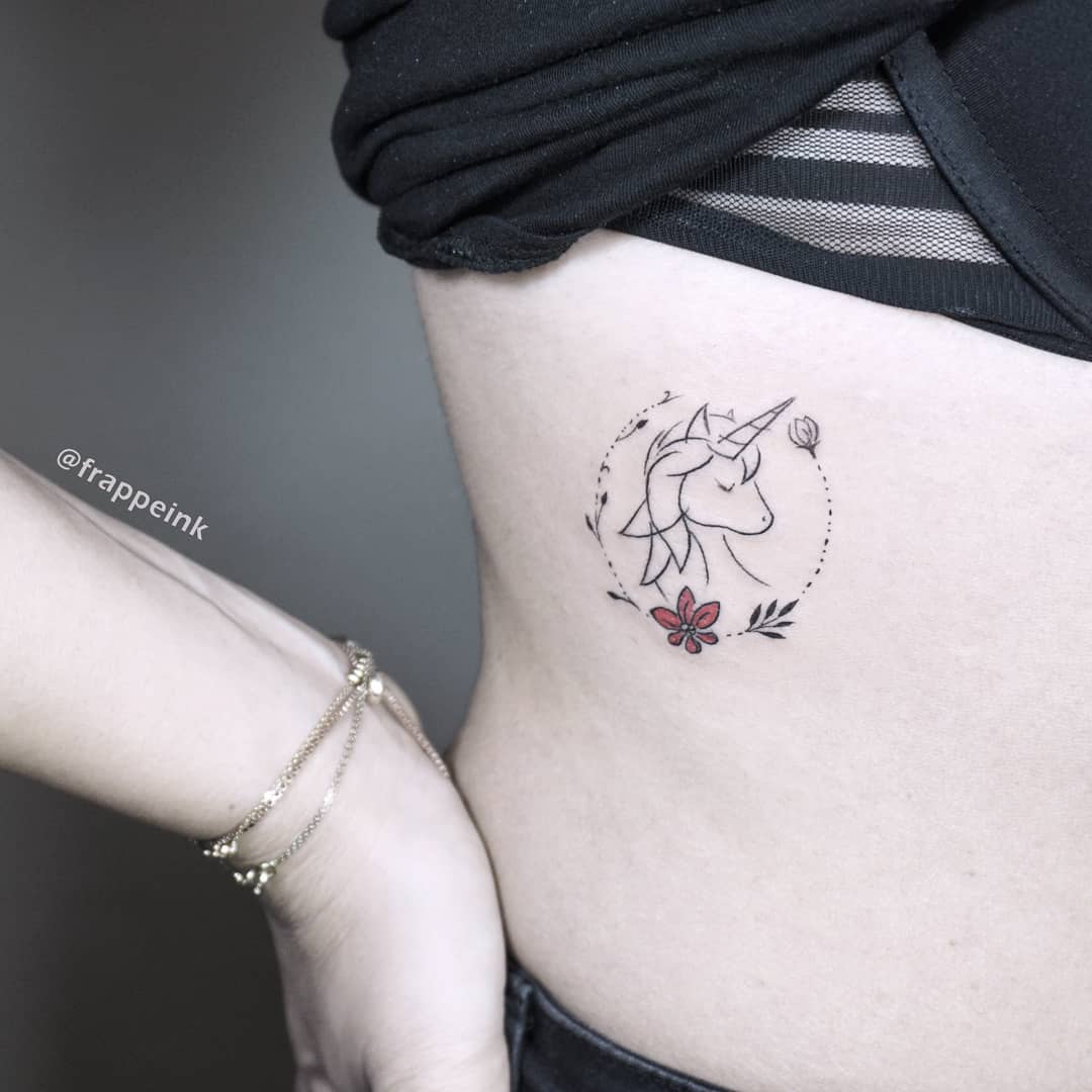 Elegant unicorn tattoo with floral accents