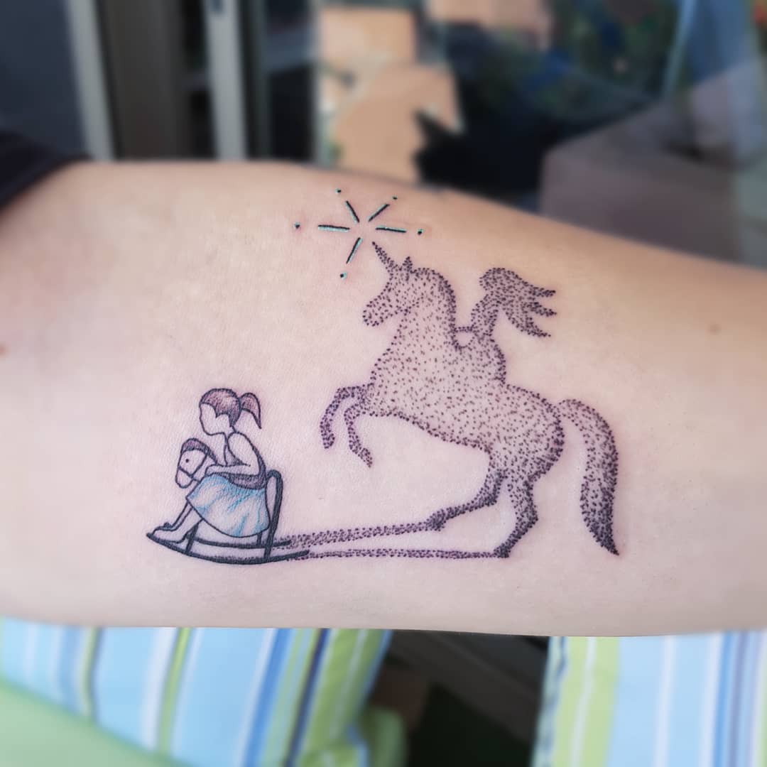 Playful unicorn tattoo with whimsical girl design