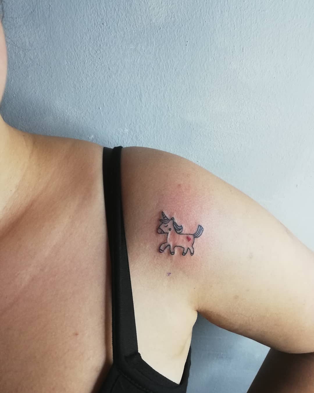 Whimsical unicorn tattoo on the shoulder