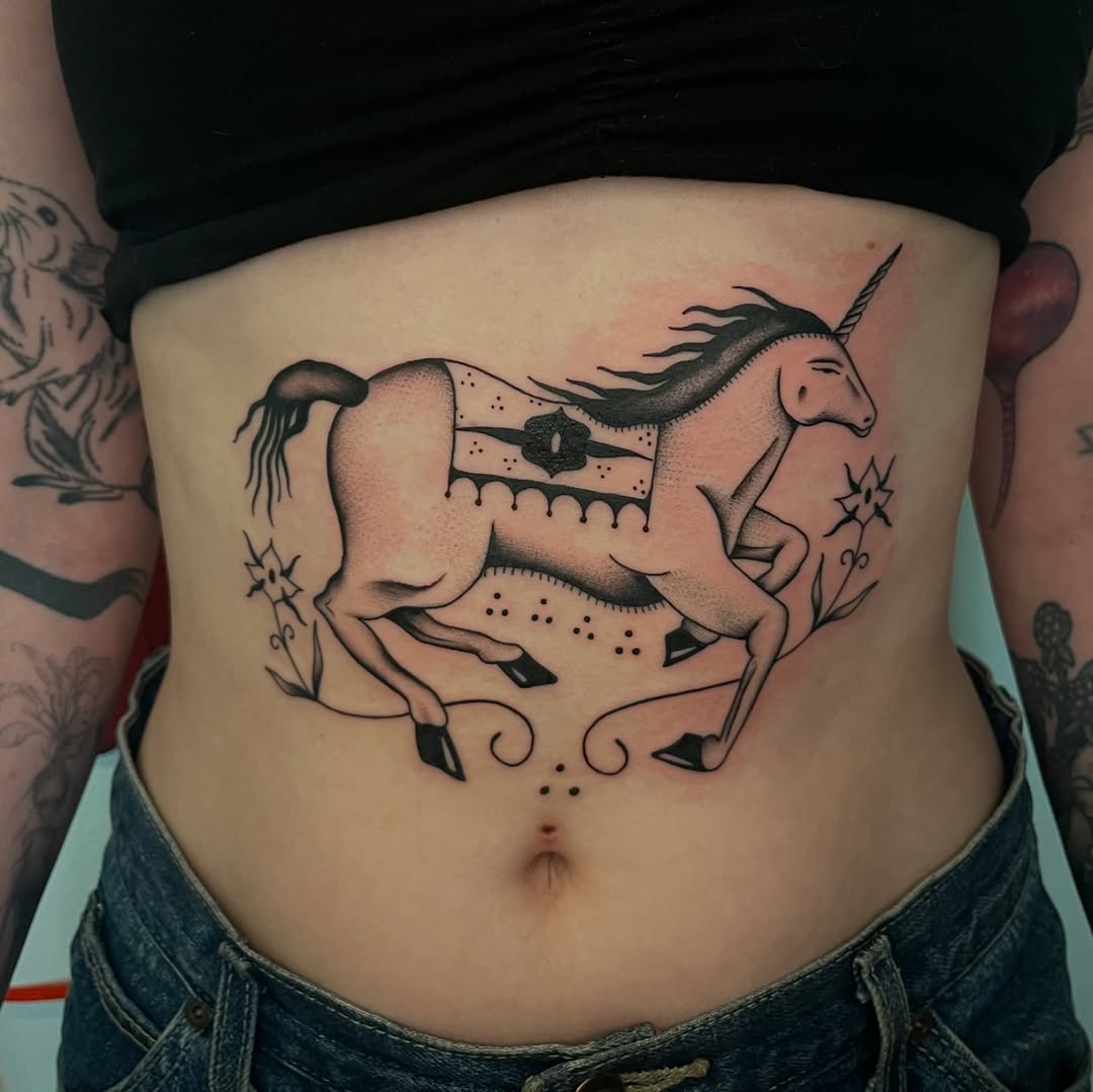 Stunning unicorn belly tattoo captures fantasy essence